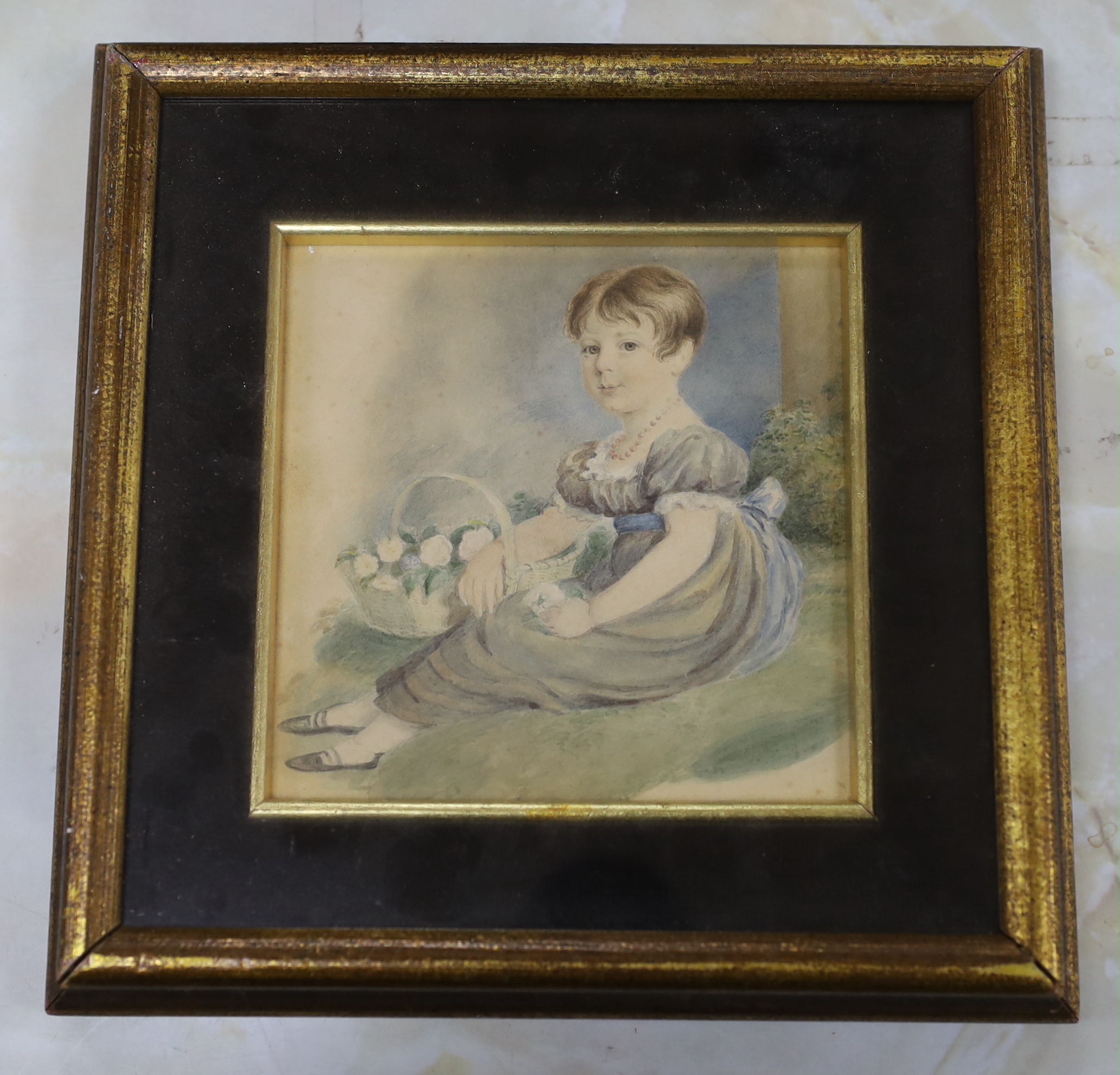 Early 19th century English School, watercolour, Seated girl holding a basket of flowers, 13cm x 13cm